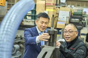 社長が市長に機械の説明をしている様子